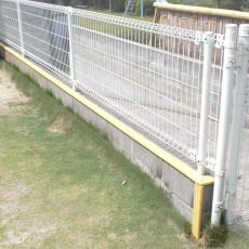 フェンスの足場に「Lステップ」を貼り付けて安全対策を施した例
